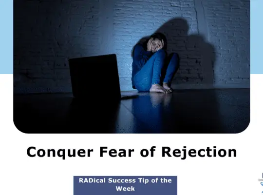 Young girl looking at a computer screen in a dimly lit room, her face showing fear, symbolizing the challenge of overcoming the fear of rejection.