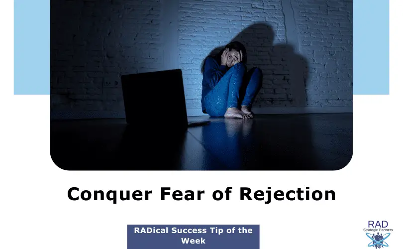 Young girl looking at a computer screen in a dimly lit room, her face showing fear, symbolizing the challenge of overcoming the fear of rejection.