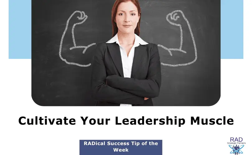 Confident businesswoman with folded arms standing in front of a chalkboard with muscle arms drawn behind her, symbolizing the cultivation of leadership strength.